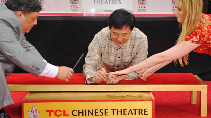 Jackie Chan signs his name at the TCL Chinese Theatre