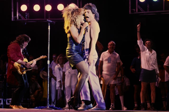 Bill Graham motions from backstage as Tina Turner and Mick Jagger perform at Live Aid.
