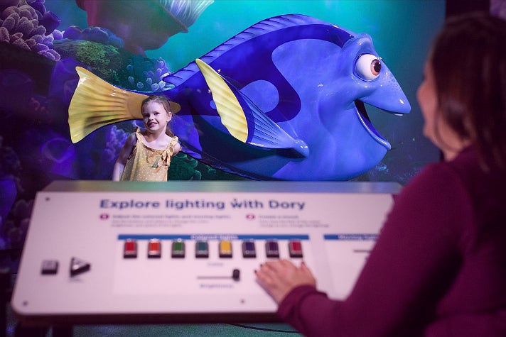 Visitors adjust the lighting for their photo with Dory at "The Science Behind Pixar"