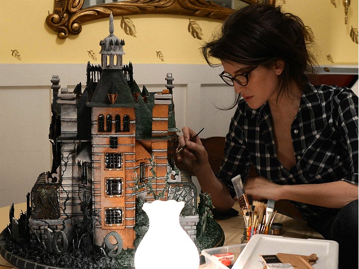 Christine McConnell puts the finishing touches on the Peculiar gingerbread house