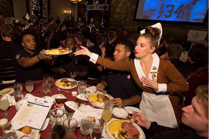 Stanford player receives a prime rib plate at 60th Lawry's Beef Bowl