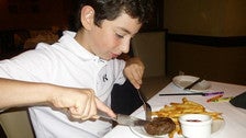 Kid enjoying a 4 oz filet mignon at Ruth&#039;s Chris